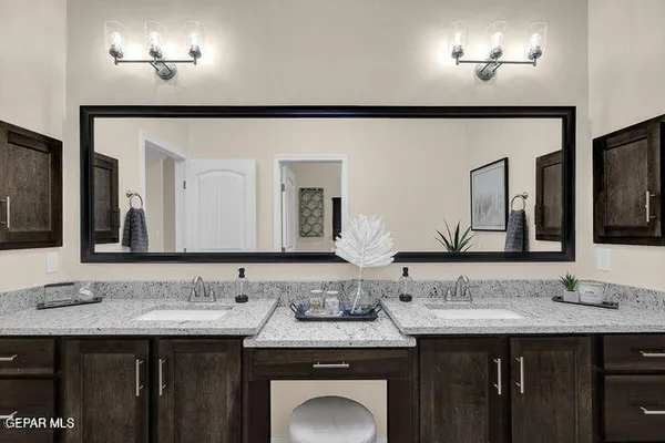 a bathroom with a granite countertop sink and a mirror
