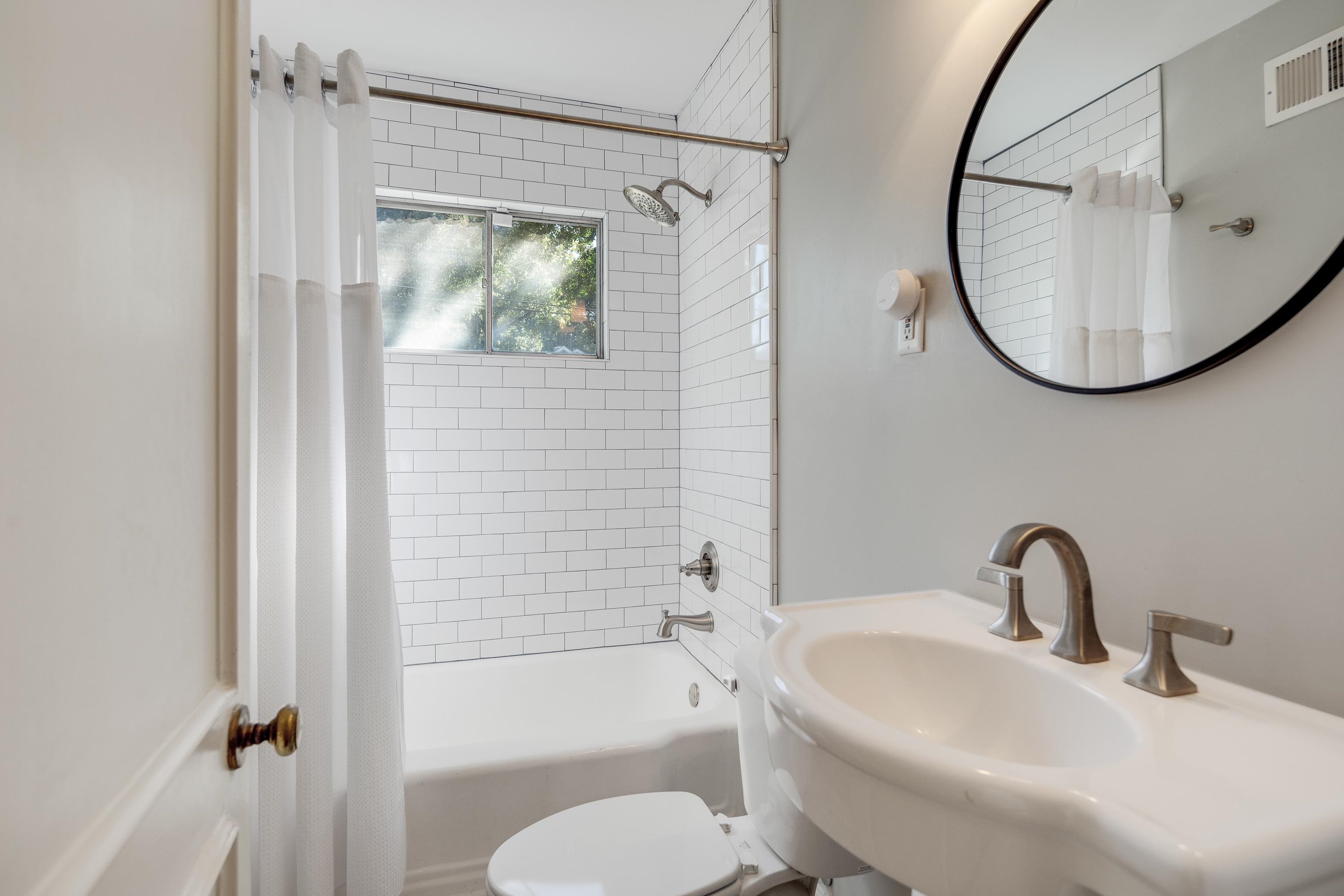 5060 Rich Road Memphis, TN 38117 - Photo 19 of 25 a bathroom with a sink a mirror a bathtub and shower