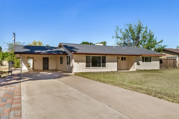 a front view of a house with a garden and yard