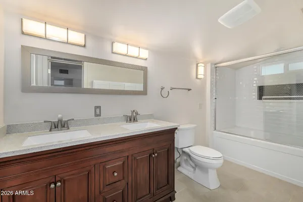 a view of an empty room with cabinet and a ceiling fan