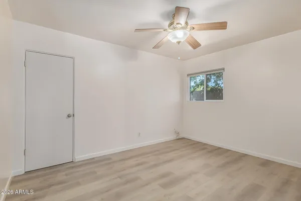an empty room with fan and windows