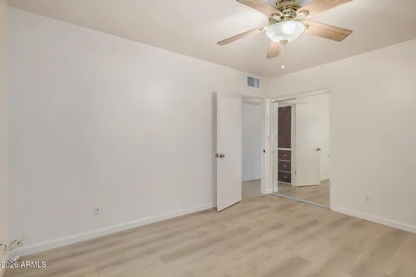 an empty room with windows and fan