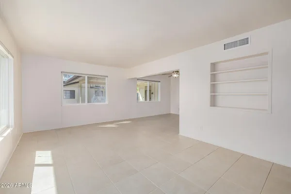 an empty room with windows and white walls