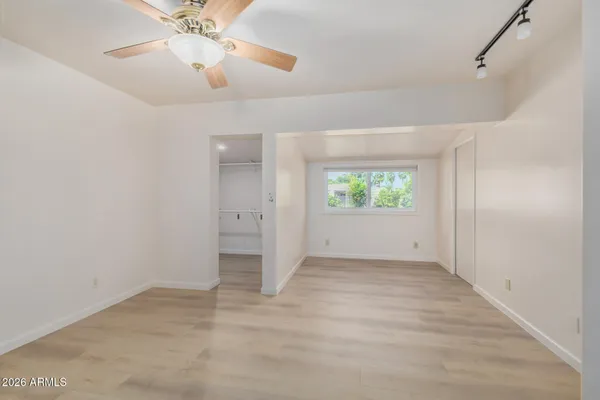 an empty room with windows and fan