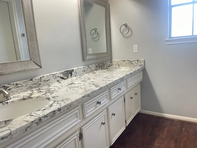a bathroom with a granite countertop sink and a mirror
