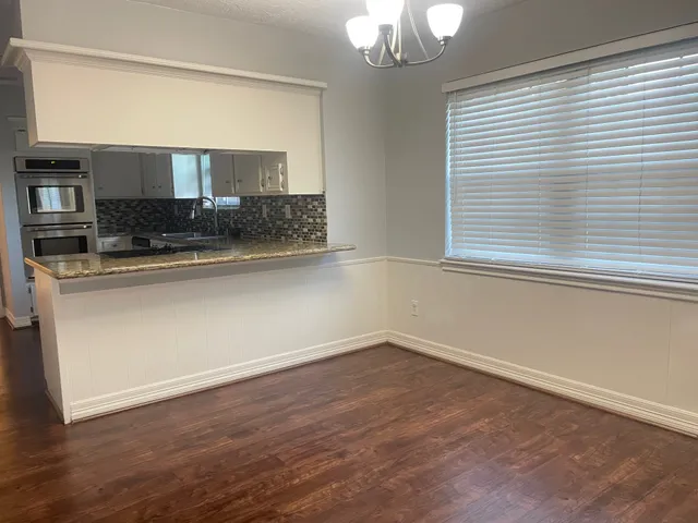 an empty room with wooden floor and window