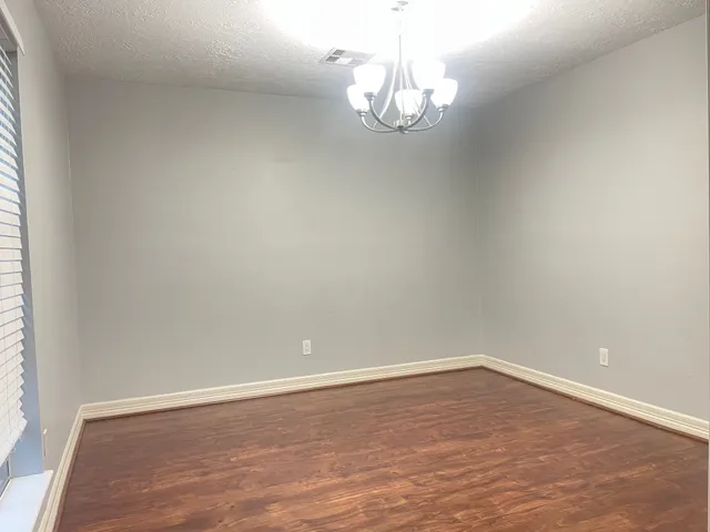 a view of a room with wooden floor and chandelier