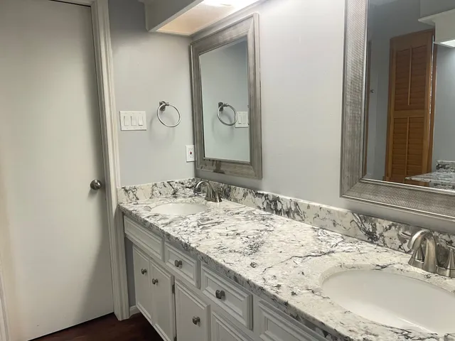 a bathroom with a granite countertop sink and a mirror