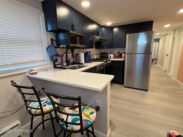 a kitchen with a table chairs refrigerator and microwave