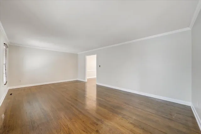 a large white kitchen with cabinets a sink a counter top space stainless steel appliances and a chandelier