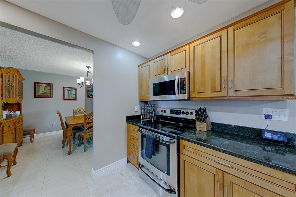 9628 122nd Way Seminole, FL 33772 - Photo 11 of 53 a kitchen with stainless steel appliances granite countertop a stove a sink and a microwave