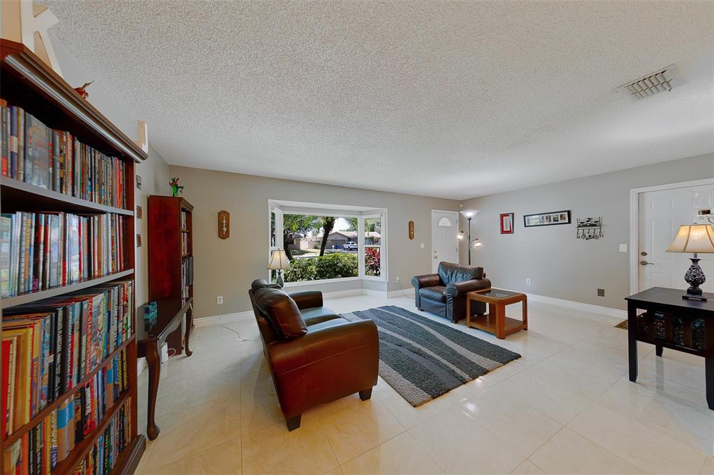 9628 122nd Way Seminole, FL 33772 - Photo 4 of 53 a living room with furniture and a book shelf