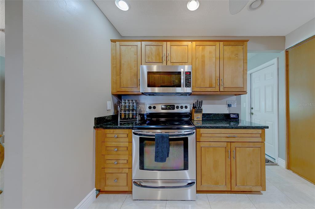 9628 122nd Way Seminole, FL 33772 - Photo 10 of 53 a kitchen with stainless steel appliances granite countertop a stove and a microwave