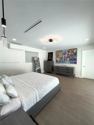 a spacious bedroom with a bed and dresser