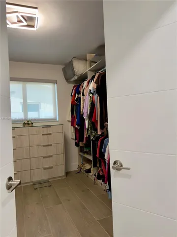 a view of walk in closet with clothes