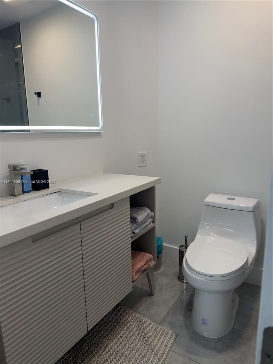 2350 Northeast 194th Street Miami, FL 33180 - Photo 18 of 24 a bathroom with a toilet sink and mirror