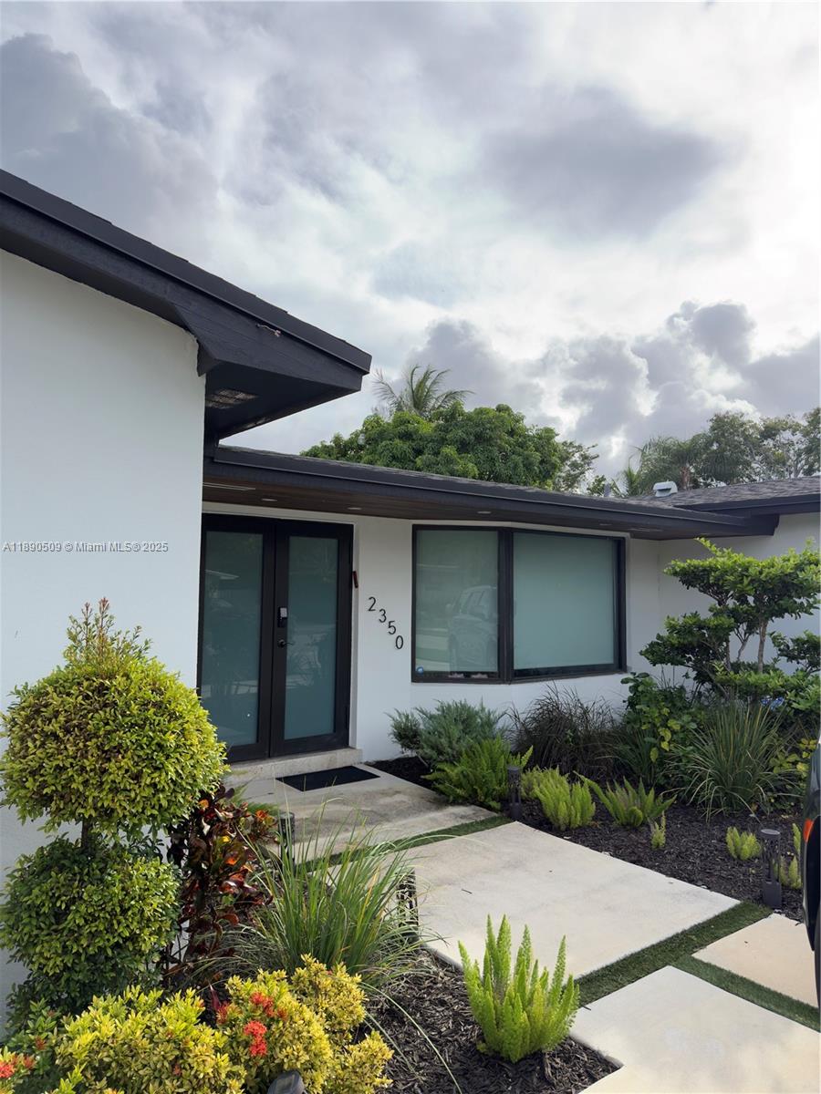 2350 Northeast 194th Street Miami, FL 33180 - Photo 2 of 24 front view of a house with a yard