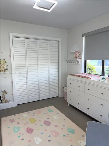 a view of a bedroom with window and cabinet