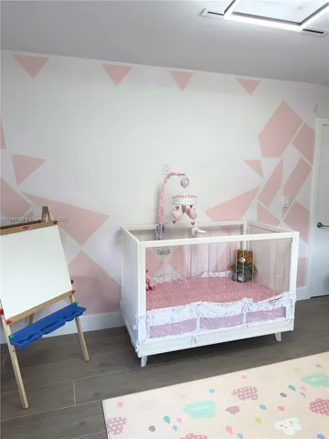 a bedroom with a bed and a lamp on the dresser