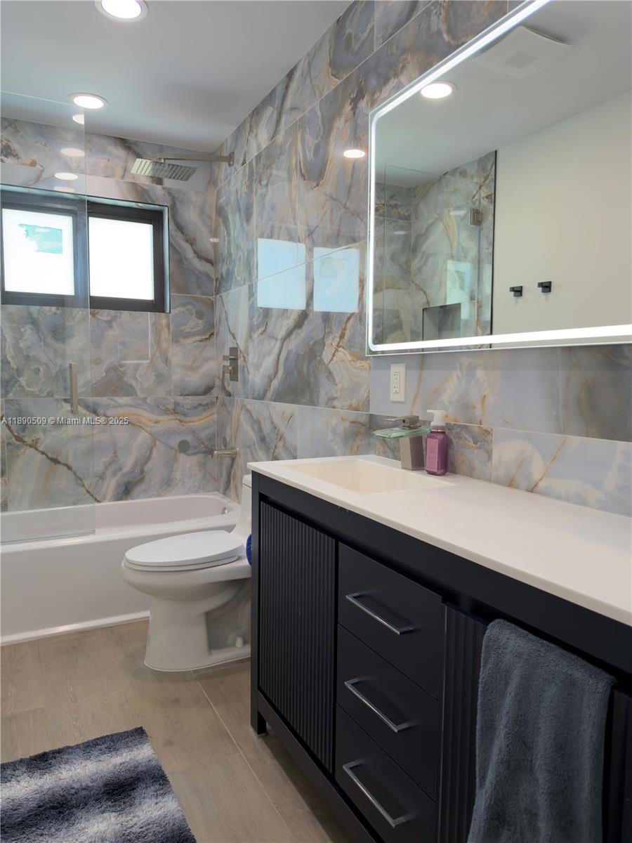 2350 Northeast 194th Street Miami, FL 33180 - Photo 23 of 24 a bathroom with a sink a toilet and bathtub
