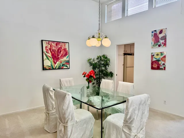 a dining room with furniture and a potted plant