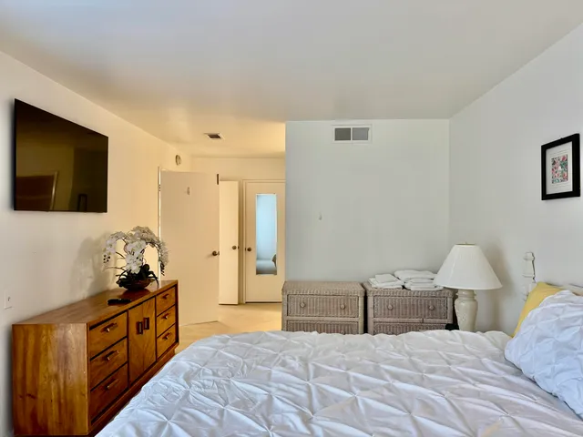 a large bedroom with a bed and a flat screen tv