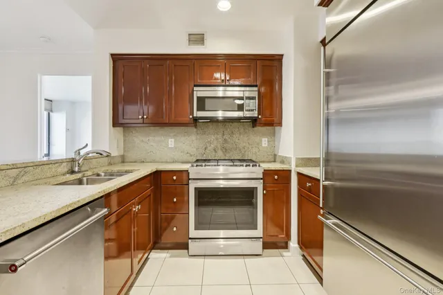 a kitchen with stainless steel appliances granite countertop a stove microwave and sink