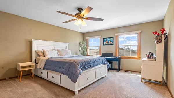 a spacious bedroom with a bed and a chandelier