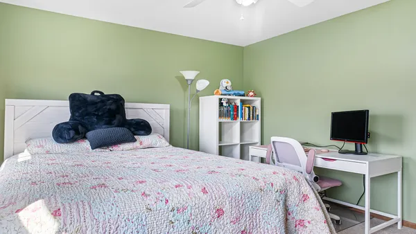 a bedroom with a bed and a computer on a table