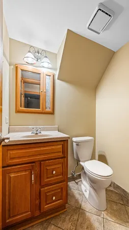 a bathroom with a toilet a sink and mirror