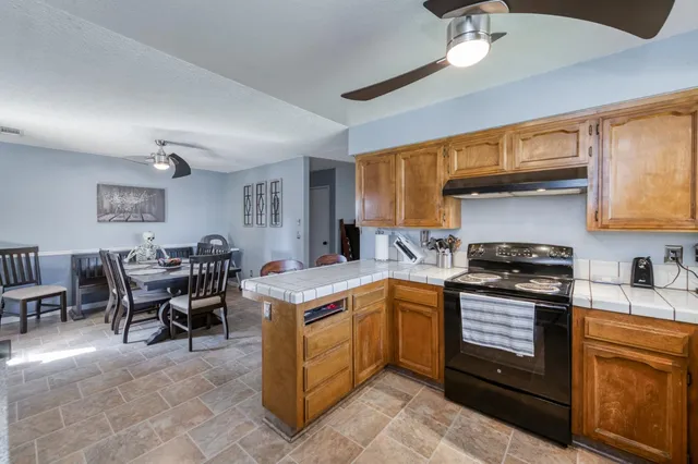 a kitchen with a stove a sink a dining table and chairs