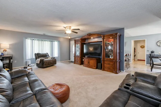 a living room with furniture a flat screen tv and a chandelier