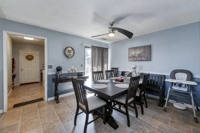 a view of a dining room and livingroom with furniture a flat screen tv and a clock