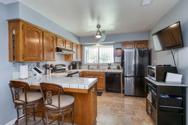 a kitchen with stainless steel appliances granite countertop a stove refrigerator sink and microwave