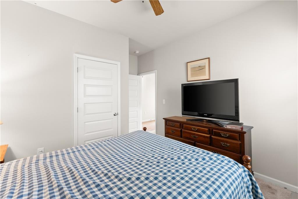 63 Conroe Court Hoschton, GA 30548 - Photo 19 of 44 a bedroom with a bed and a flat screen tv
