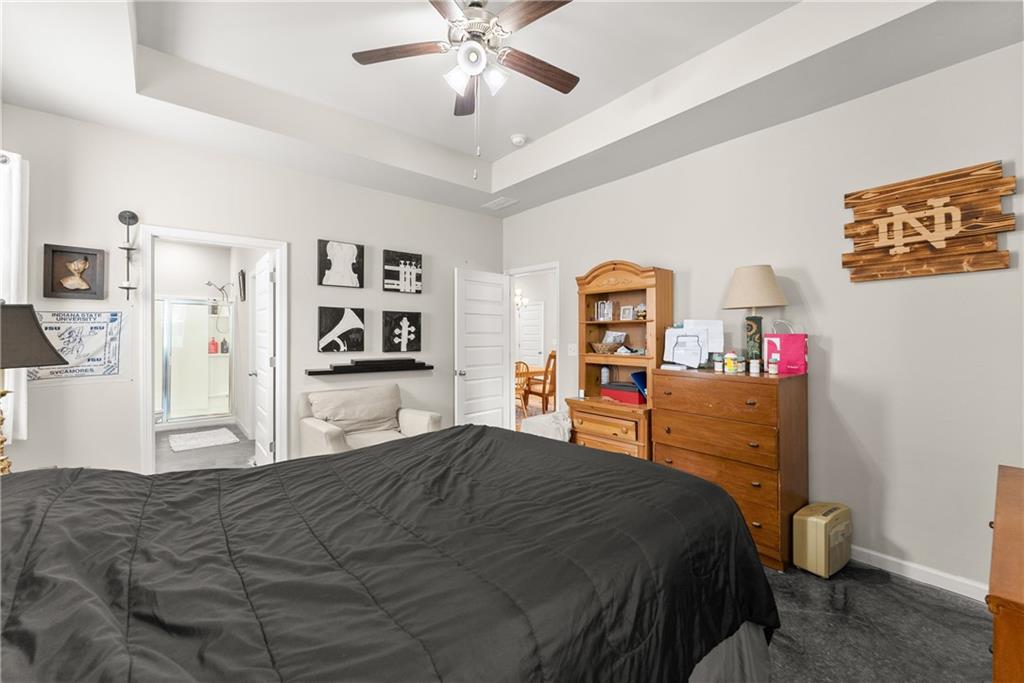 63 Conroe Court Hoschton, GA 30548 - Photo 25 of 44 a bedroom with a large bed and a chandelier