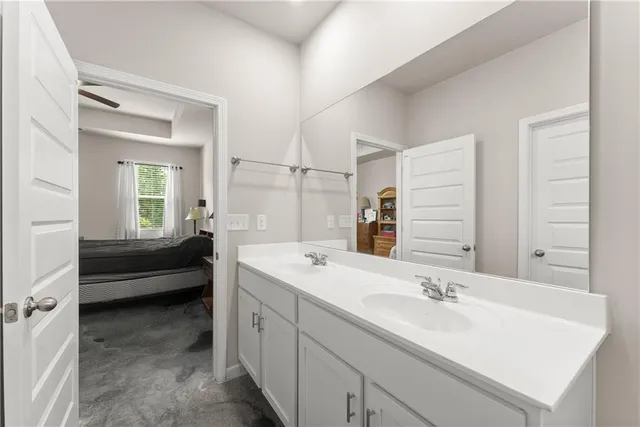 a en suite bathroom with a double vanity sink a mirror and a bathtub