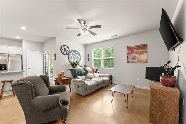 a living room with furniture a flat screen tv and a window