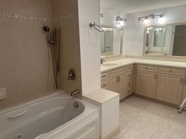 a bathroom with a tub sink shower and mirror