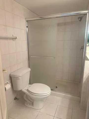 a white toilet sitting next to a bath tub and a shower
