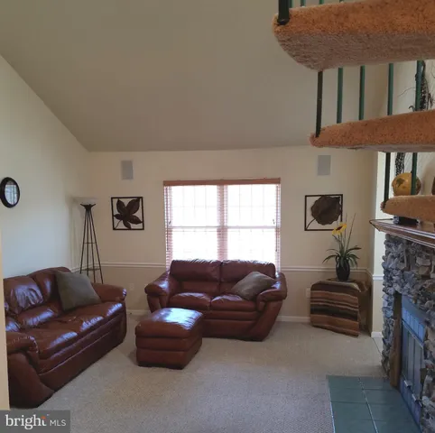 a living room with furniture a fireplace and a window