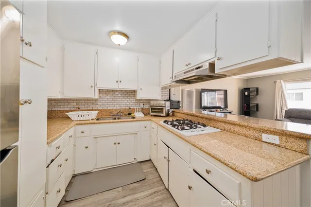 a kitchen with granite countertop white cabinets and white appliances
