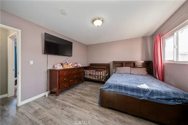 a bedroom with a bed and a flat screen tv