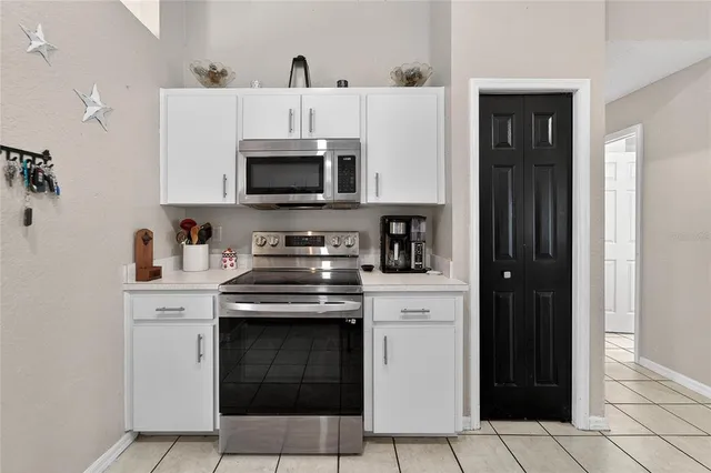 a bedroom with a large bed a chandelier and dresser