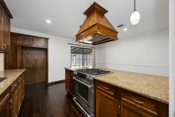a kitchen with a stove and a wooden floor