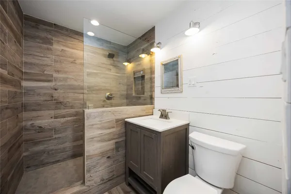 a bathroom with a toilet a sink and mirror