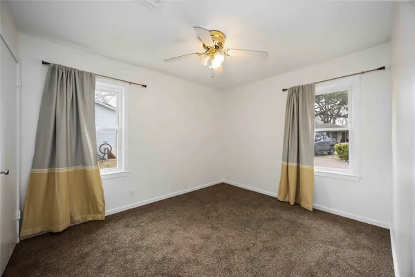 an empty room with windows and closet