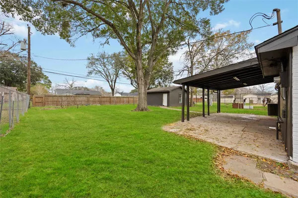 a view of a house with backyard and a tree