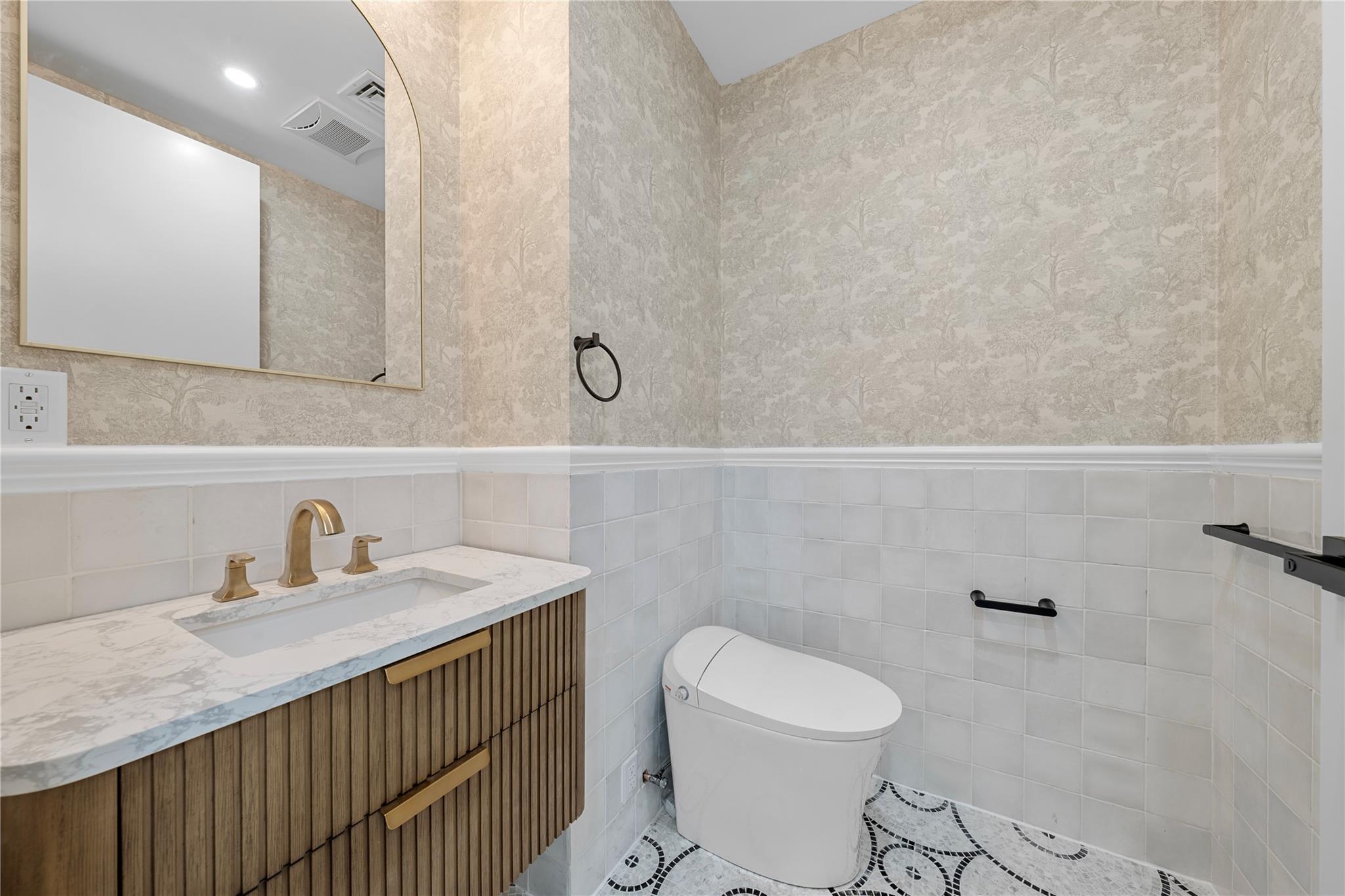 312 Fenimore Street Brooklyn, NY 11225 - Photo 12 of 37 Half bathroom with vanity, toilet, a wainscoted wall, tile walls, and tile patterned floors