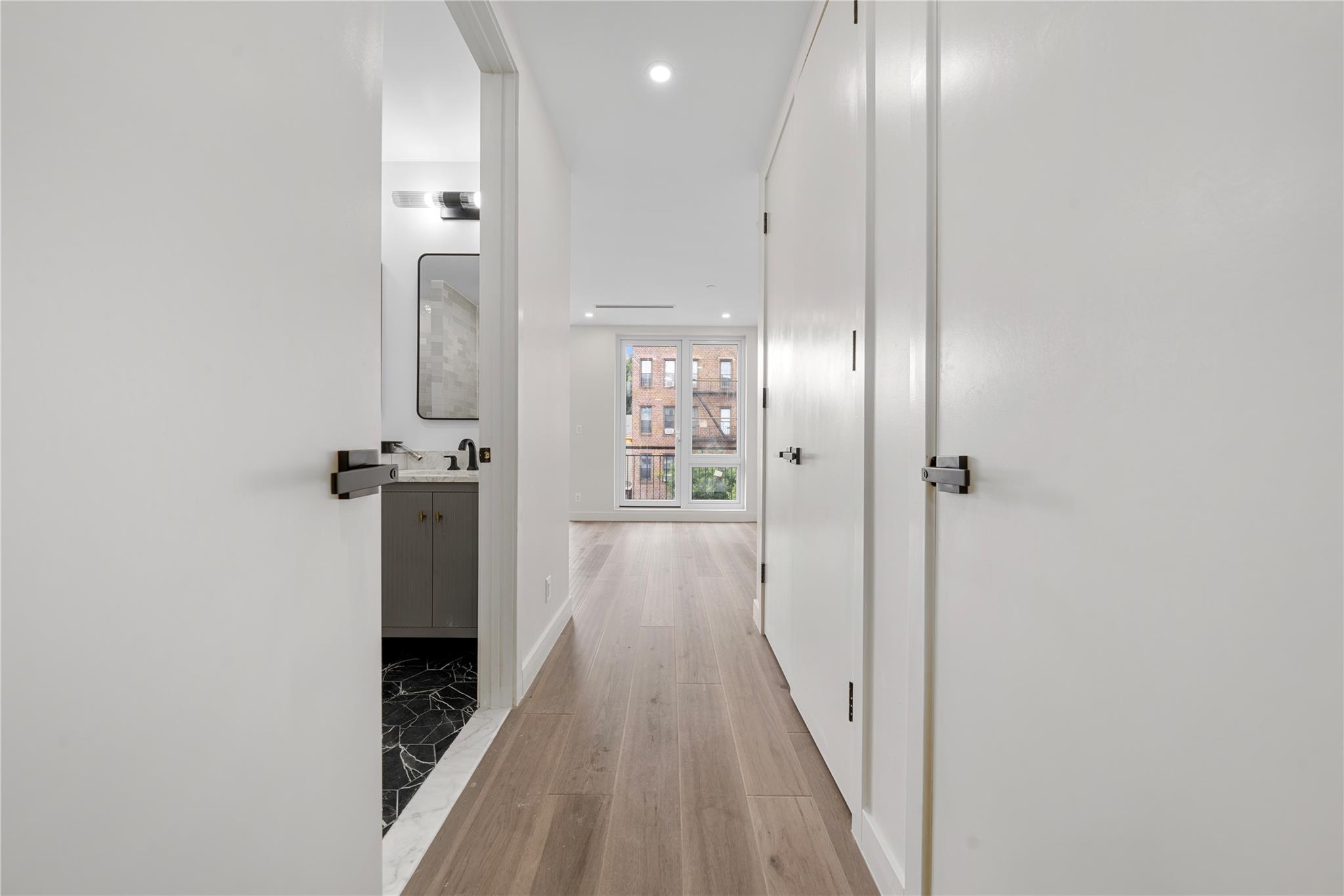 312 Fenimore Street Brooklyn, NY 11225 - Photo 17 of 37 Corridor featuring a sink, light wood-type flooring, recessed lighting, and baseboards
